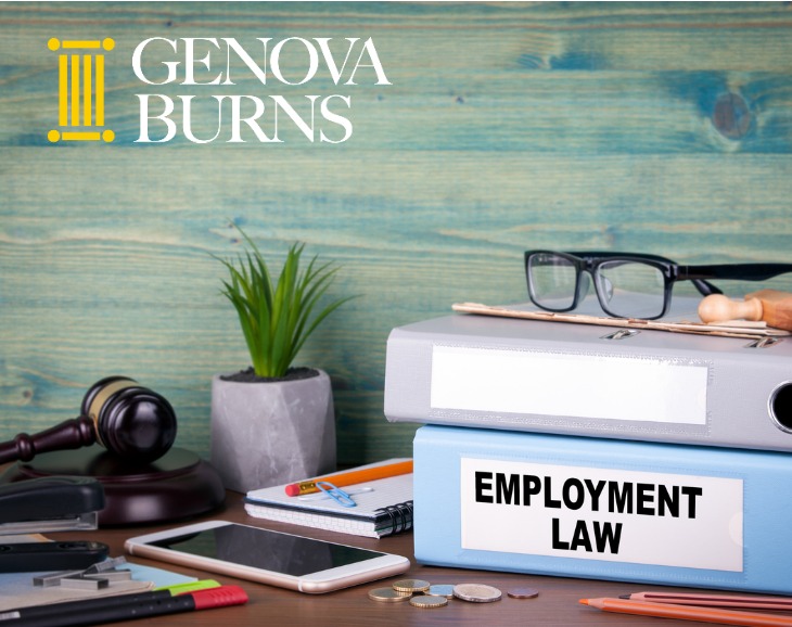 Employment law binders, gavel, plant and glasses on a desk